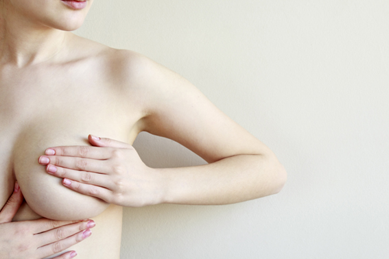 Woman controlling breast for cancer, isolated on white backgroun